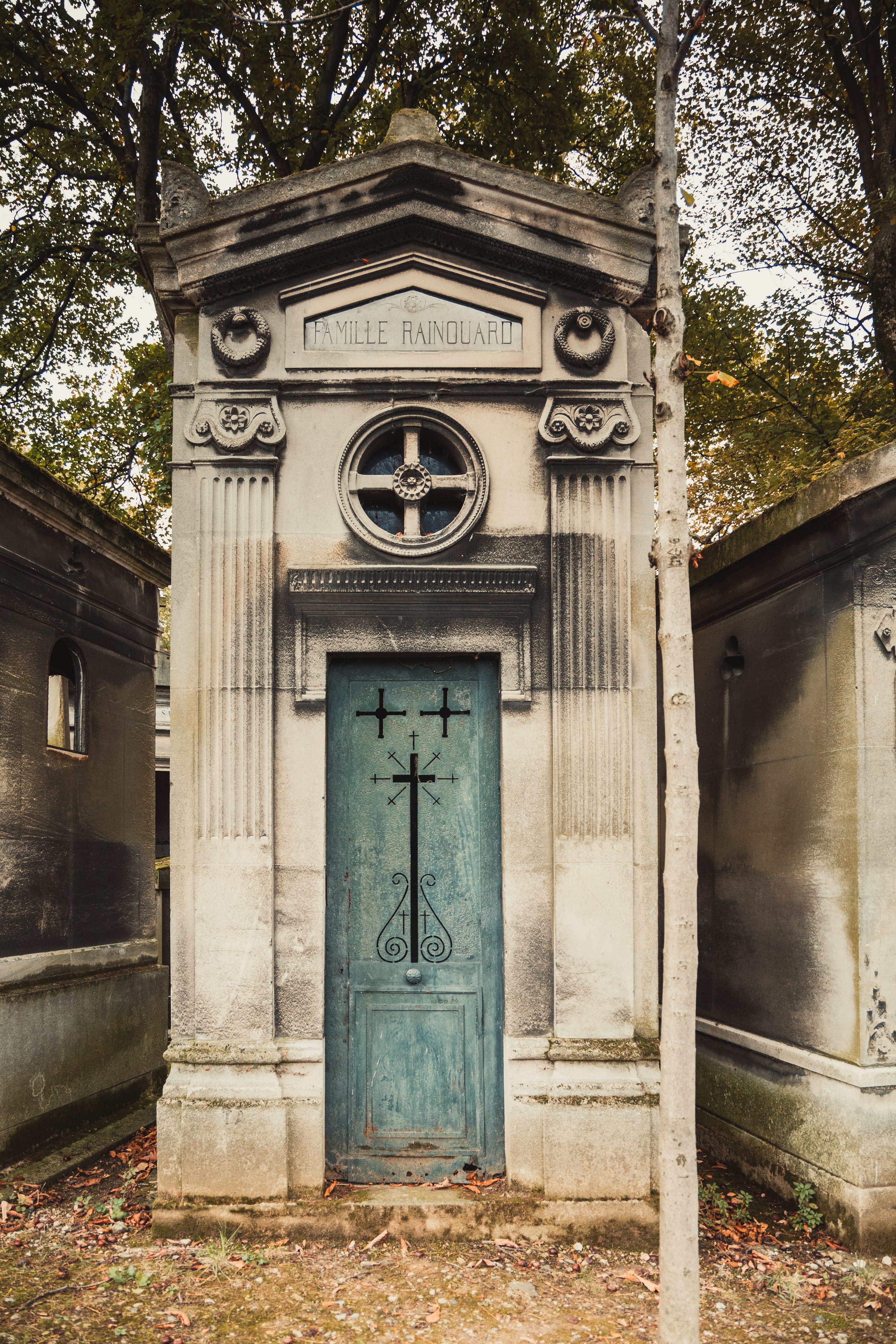 an old cemetery with a blue door and cross on it